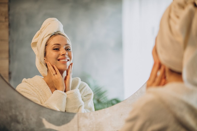 A woman applying skincare products